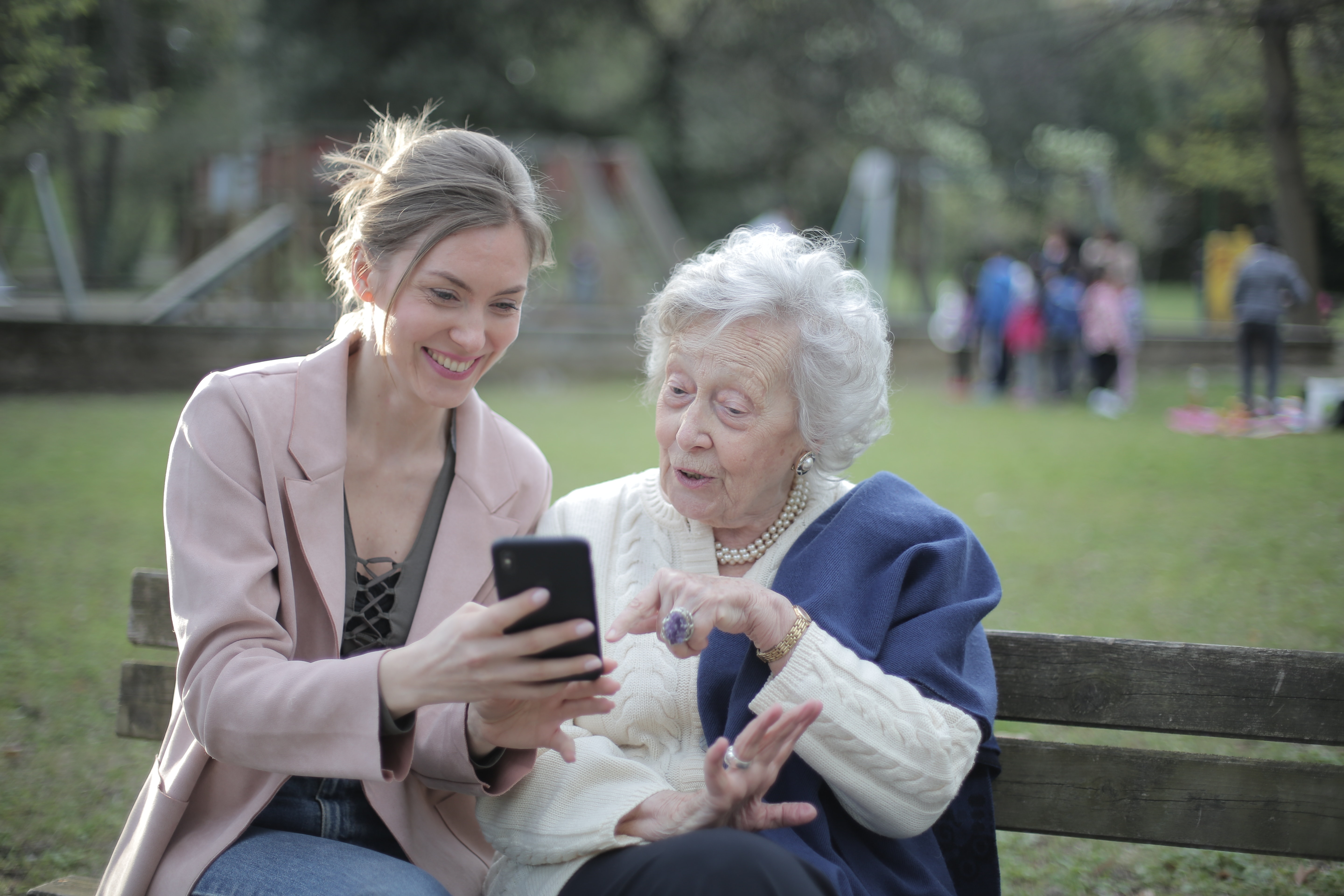 woman talking to elderly mother showing her phone